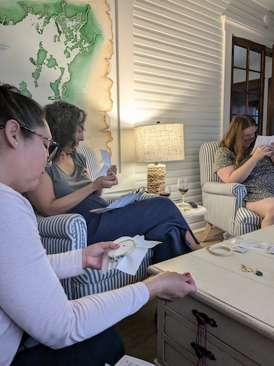 three women doing cross stitch 